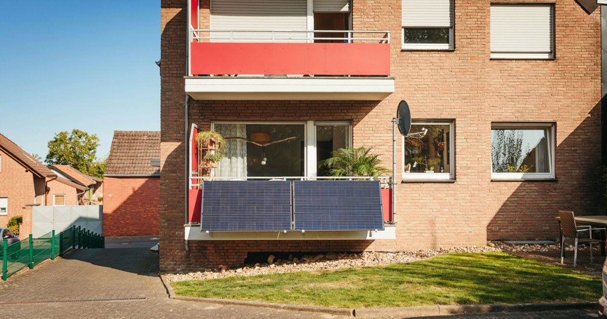 Balcony with solar panels on brick building