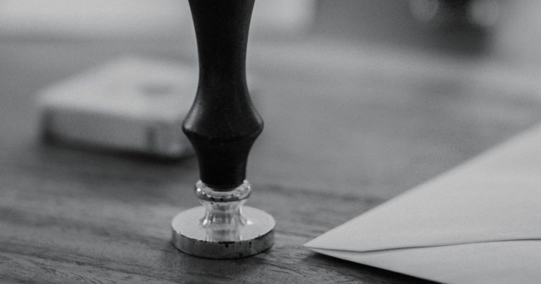 A wooden stamp sits on a wooden desk